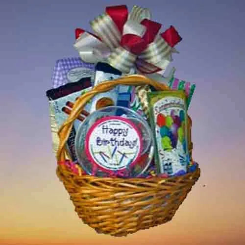 Small birthday gift basket for one with cookies and treats wrapped in cello and a colorful bow