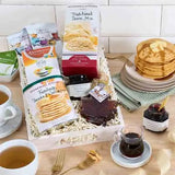 Breakfast gift basket with pancake mix, maple syrup, coffee, scone mix, and blueberry preserves in a white crate